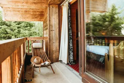 a porch of a cabin with a chair and a window at Les Grands Montets Hotel & Spa in Chamonix-Mont-Blanc