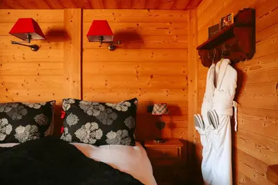 a bedroom with a bed and a wooden wall at Les Grands Montets Hotel & Spa in Chamonix-Mont-Blanc