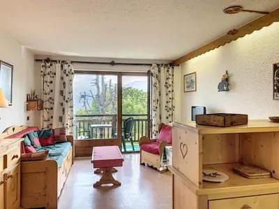 a room with a bed and a window with a balcony at Joli 2 pièces + studio au centre de Combloux - FR-1-560-74 in Combloux