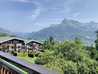 a view of a hotel with mountains in the background at Joli 2 pièces + studio au centre de Combloux - FR-1-560-74 in Combloux