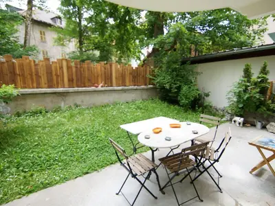 a kitchen with a table with chairs and a television at Apartment Les Jardins de l'Astoria by Interhome in Chamonix-Mont-Blanc
