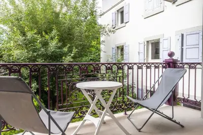 a patio with two chairs and a table on a balcony at Villa Vallet- Newly renovated 2 bedroom nestled just off the main street in Chamonix-Mont-Blanc