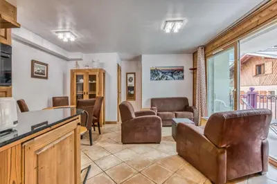a living room with leather chairs and a table at Villa Vallet- Newly renovated 2 bedroom nestled just off the main street in Chamonix-Mont-Blanc