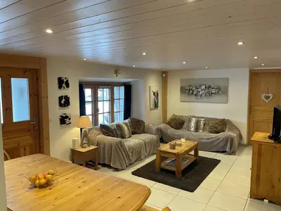 a living room with a couch and a table at Ferme rénovée 4 ch, 3 sdb, PARKING, WIFI, proche pistes et commerces - FR-1-572-25 in Arâches-la-Frasse