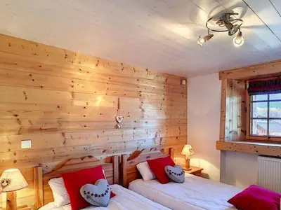 a bedroom with a wooden wall with two beds at Ferme rénovée 4 ch, 3 sdb, PARKING, WIFI, proche pistes et commerces - FR-1-572-25 in Arâches-la-Frasse