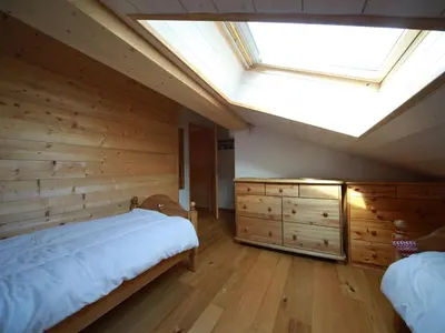 a bedroom with a large bed and a skylight at Ferme rénovée 12 pers, 450m des pistes, navette gratuite, balcon S-O, parking, WIFI - FR-1-572-23 in Arâches-la-Frasse