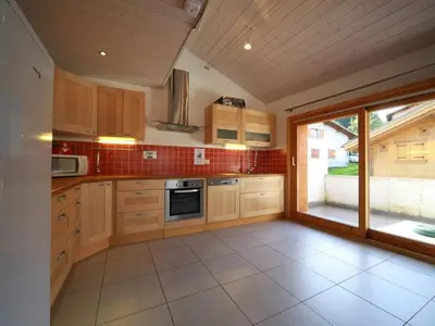 a kitchen with wooden cabinets and a large window at Ferme rénovée 12 pers, 450m des pistes, navette gratuite, balcon S-O, parking, WIFI - FR-1-572-23 in Arâches-la-Frasse