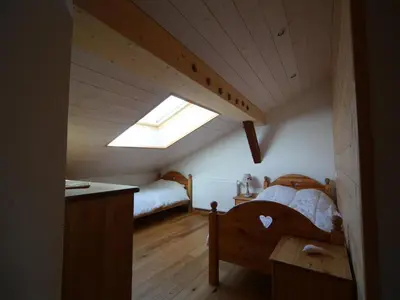 a attic bedroom with a bed and a skylight at Ferme rénovée 12 pers, 450m des pistes, navette gratuite, balcon S-O, parking, WIFI - FR-1-572-23 in Arâches-la-Frasse