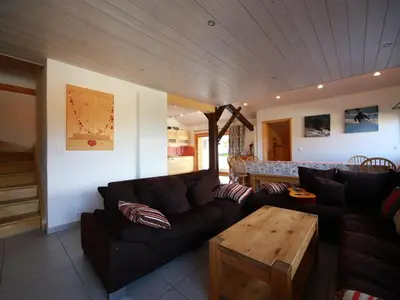 a living room with a couch and a table at Ferme rénovée 12 pers, 450m des pistes, navette gratuite, balcon S-O, parking, WIFI - FR-1-572-23 in Arâches-la-Frasse