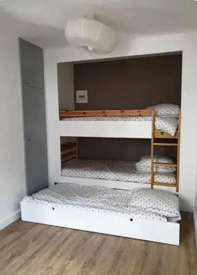 a room with three bunk beds in a room at Appartement Paccard, Centre Ville in Chamonix-Mont-Blanc