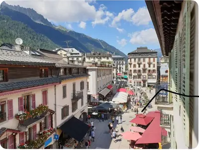 a group of people walking down a street in a town at Appartement Paccard, Centre Ville in Chamonix-Mont-Blanc