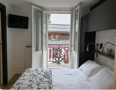 a bedroom with a bed and a large window at Appartement Paccard, Centre Ville in Chamonix-Mont-Blanc