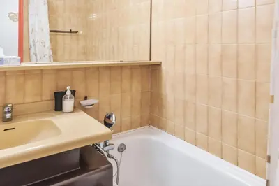a bathroom with a bath tub and a sink at Appartement Courmayeur - Welkeys in Chamonix-Mont-Blanc