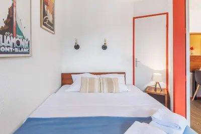 a bedroom with a bed with white sheets at Appartement Courmayeur - Welkeys in Chamonix-Mont-Blanc