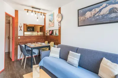 a living room with a blue couch and a table at Appartement Courmayeur - Welkeys in Chamonix-Mont-Blanc