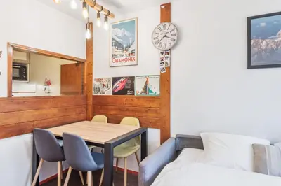 a dining room with a table and chairs and a clock at Appartement Courmayeur - Welkeys in Chamonix-Mont-Blanc