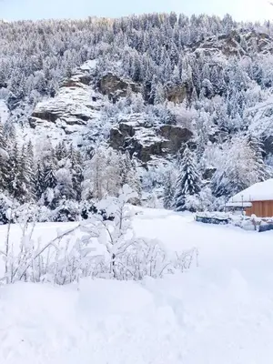 a snow covered field with a building and trees at Belle Vue de St Gervais in Saint-Gervais-les-Bains