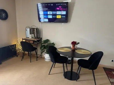 a dining room with a table and chairs and a tv at Belle Vue de St Gervais in Saint-Gervais-les-Bains