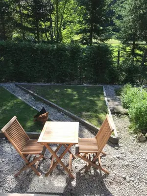 a wooden table and two chairs in a garden at Chalet Cristal Trail in Chamonix-Mont-Blanc