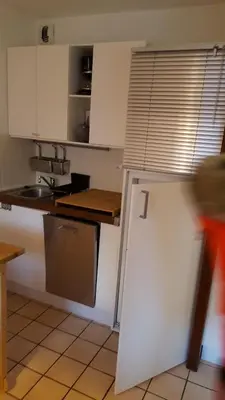 a kitchen with white cabinets and a refrigerator at Studio 4 personnes RDC avec jardin et parking sous terrain in Samoëns