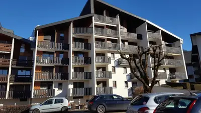 an apartment building with cars parked in front of it at Studio 4 personnes RDC avec jardin et parking sous terrain in Samoëns