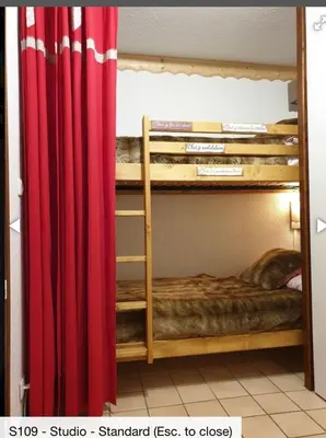 a room with two bunk beds with a red curtain at Studio 4 personnes RDC avec jardin et parking sous terrain in Samoëns