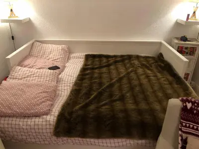 a small bed with a blanket on top of it at Studio 4 personnes RDC avec jardin et parking sous terrain in Samoëns