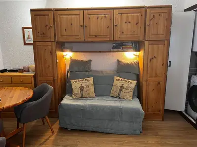 a bedroom with a red bed and a table and chairs at Le Petit Cocon in Les Houches