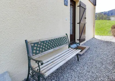 a wooden bench sitting next to a building at Le Petit Cocon in Les Houches