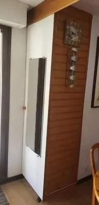 a wooden door in a room with a mirror at Le Petit Cocon in Les Houches