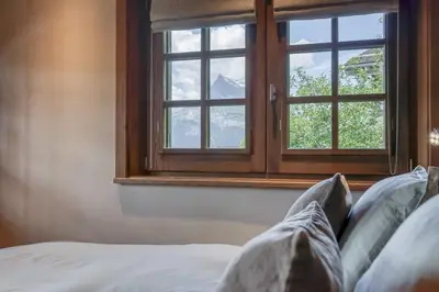 a bedroom with a window and a bed with pillows at Chalet Carline in Combloux