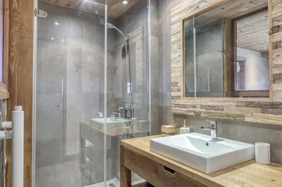 a bathroom with a sink and a glass shower at Chalet Carline in Combloux