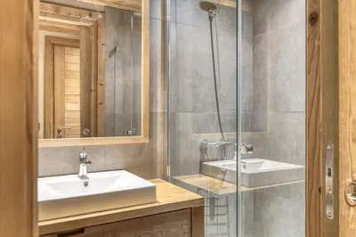 a bathroom with a sink and a glass shower at Chalet Carline in Combloux