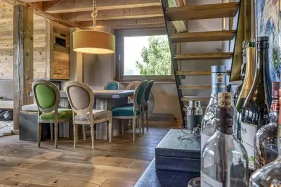a dining room with a table and chairs and a window at Chalet Carline in Combloux
