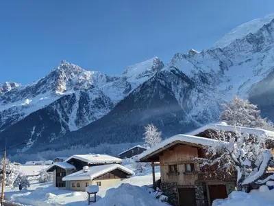 a snow covered mountain range with houses and mountains at Les Alpages - Newly Renovated - 2bed - Equipment Storage - Mont-Blanc Views in Les Houches
