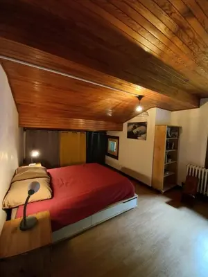 a bedroom with a large bed with a wooden ceiling at Logement mansardé dans maison avec jardin en bord de piste, vue montagne in Les Houches