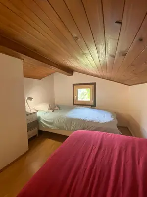 a bedroom with a bed and a wooden ceiling at Logement mansardé dans maison avec jardin en bord de piste, vue montagne in Les Houches
