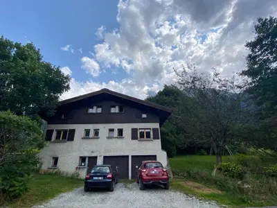 two cars parked in front of a house at Logement mansardé dans maison avec jardin en bord de piste, vue montagne in Les Houches