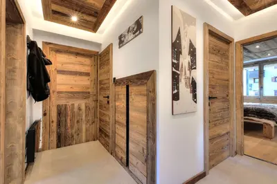 a hallway with wooden doors and wooden ceilings at Appartement familial au pied de la télécabine 4* in Saint-Gervais-les-Bains