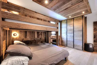 a bedroom with a large bed with wooden walls at Appartement familial au pied de la télécabine 4* in Saint-Gervais-les-Bains
