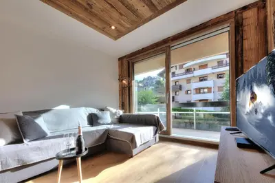 a living room with a couch and a large window at Appartement familial au pied de la télécabine 4* in Saint-Gervais-les-Bains