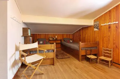 a room with wooden walls and a bed and a desk at The Historic Chalet Les Allognes Mont-Blanc views in Les Houches