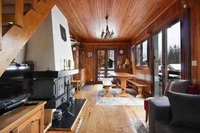 a living room with a fireplace and a tv at The Historic Chalet Les Allognes Mont-Blanc views in Les Houches