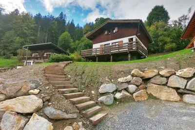 a house on a hill with stairs in front of it at The Historic Chalet Les Allognes Mont-Blanc views in Les Houches