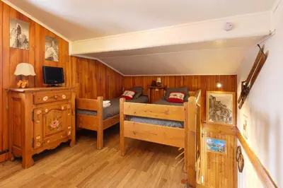 a bedroom with a bed and a tv in it at The Historic Chalet Les Allognes Mont-Blanc views in Les Houches