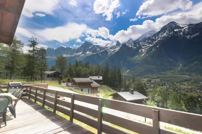 a wooden deck with a view of a mountain at The Historic Chalet Les Allognes Mont-Blanc views in Les Houches