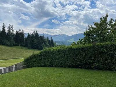 a hedge in a yard with mountains in the background at Marmotte du Jaillet Cosy and charmant appartement in Demi-Quartier