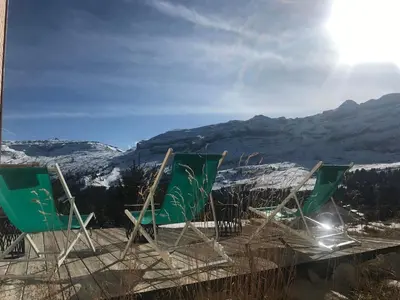three green chairs sitting on top of a mountain at MAGNIFIQUE APPARTEMENT AVEC TERRASSE et VUE IMPRENABLE SUR LE CIRQUE DE FLAINE, 2 chambres et coin montagne, 6 personnes in Flaine