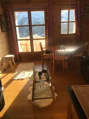 a living room with a table and chairs and a window at MAGNIFIQUE APPARTEMENT AVEC TERRASSE et VUE IMPRENABLE SUR LE CIRQUE DE FLAINE, 2 chambres et coin montagne, 6 personnes in Flaine