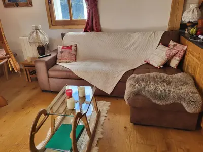 a living room with a couch and a table at MAGNIFIQUE APPARTEMENT AVEC TERRASSE et VUE IMPRENABLE SUR LE CIRQUE DE FLAINE, 2 chambres et coin montagne, 6 personnes in Flaine